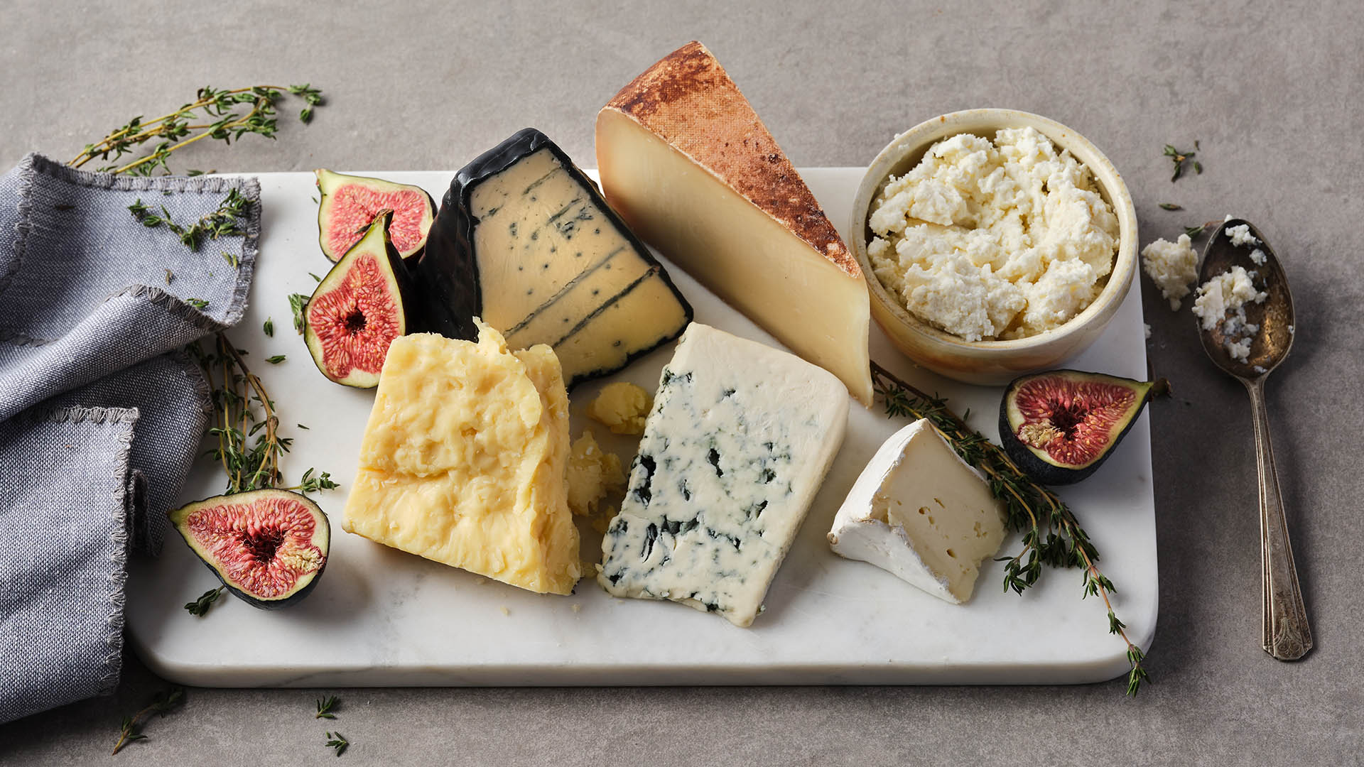 A white rectangular board with various Ontario artisanal cheeses. 