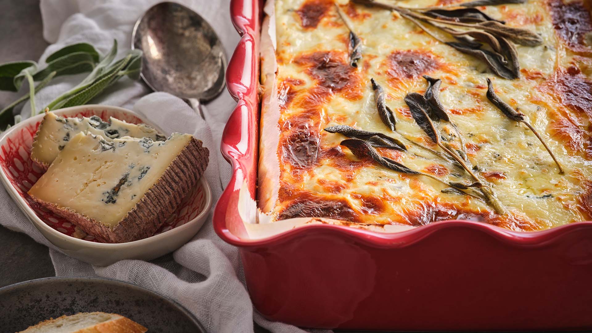 Close up shot of winter squash lasagna in red baking dish.