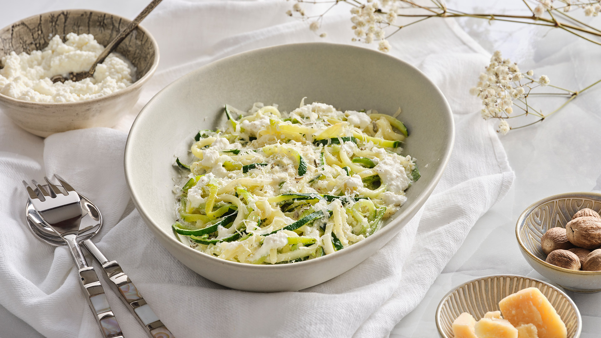 Side shot of Zucchini Noodles with Ricotta Cream Sauce in a white bowl 